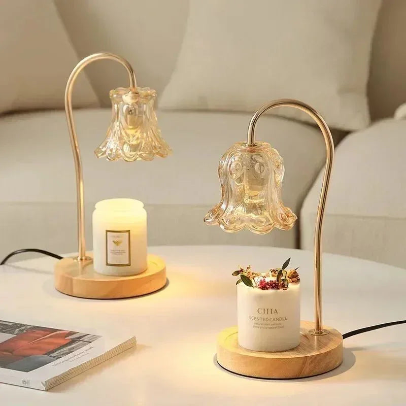 Decorative glass flower lamps with gold stands and scented candles on a modern coffee table