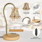 Amber glass lampshade table lamp with metal pole, wooden base, and remote control in a living room.