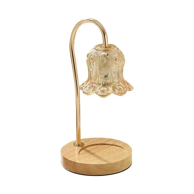 Modern glass flower-shaped table lamp with wooden base and gold stem on white background